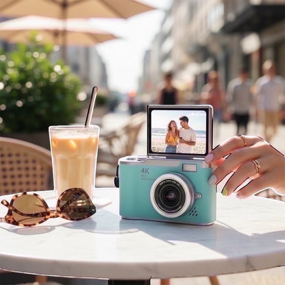 Pixie 4K digital camera in teal with a flip screen showing a woman, 48MP, 18x zoom lens.